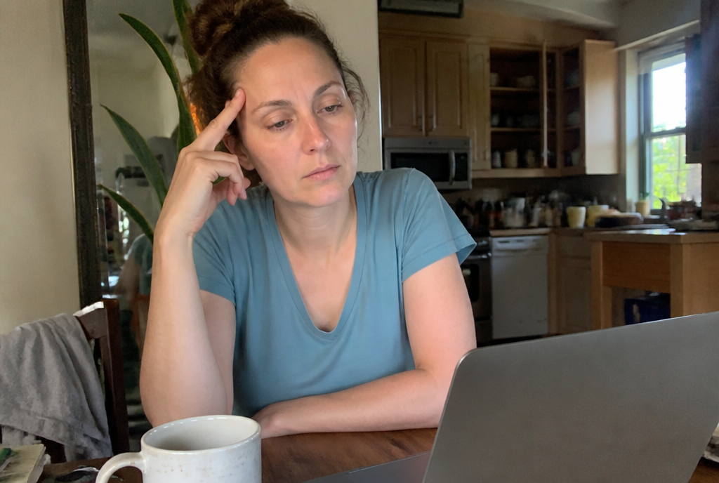 Tired woman with brain fog at kitchen table