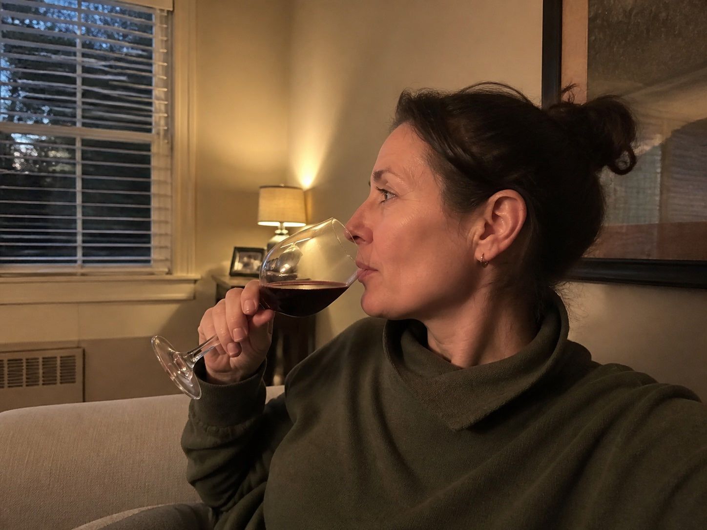 Woman relaxing at home with a glass of red wine